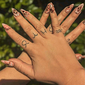 hands showing custom pink press on nail set with strawberries