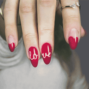 hand showing red fake press on nails that say love