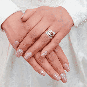 hands showing custom pink press on nails with gems